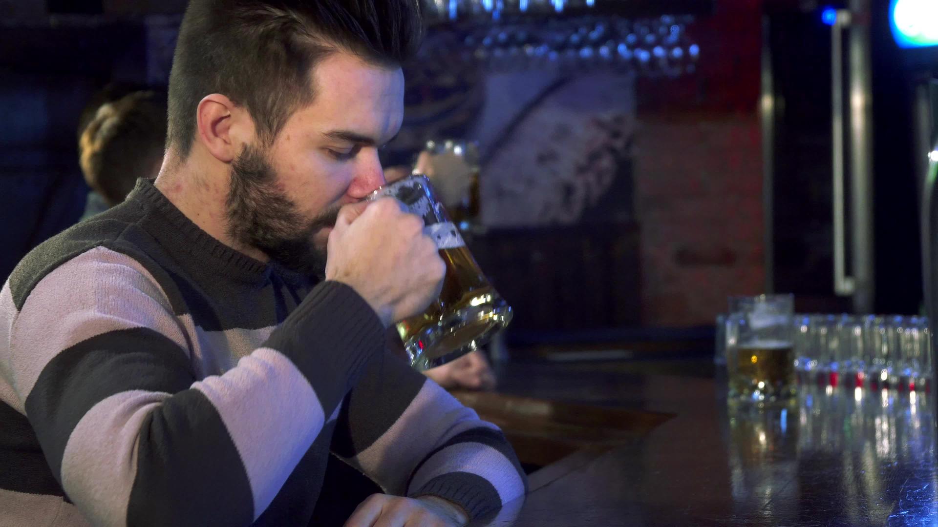 男人在酒吧里闻到啤酒的味道视频的预览图