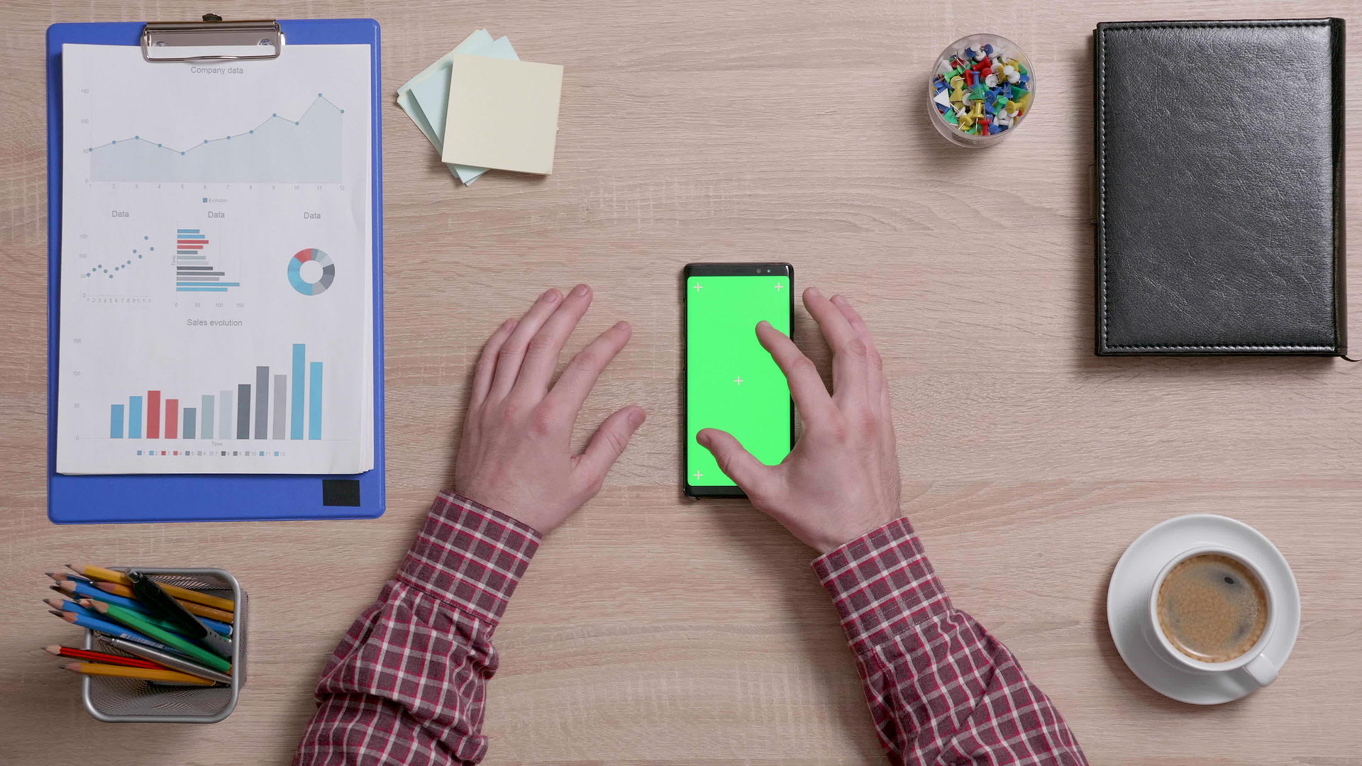 手指顶部的视图被放大并显示智能手机的绿色屏幕视频的预览图