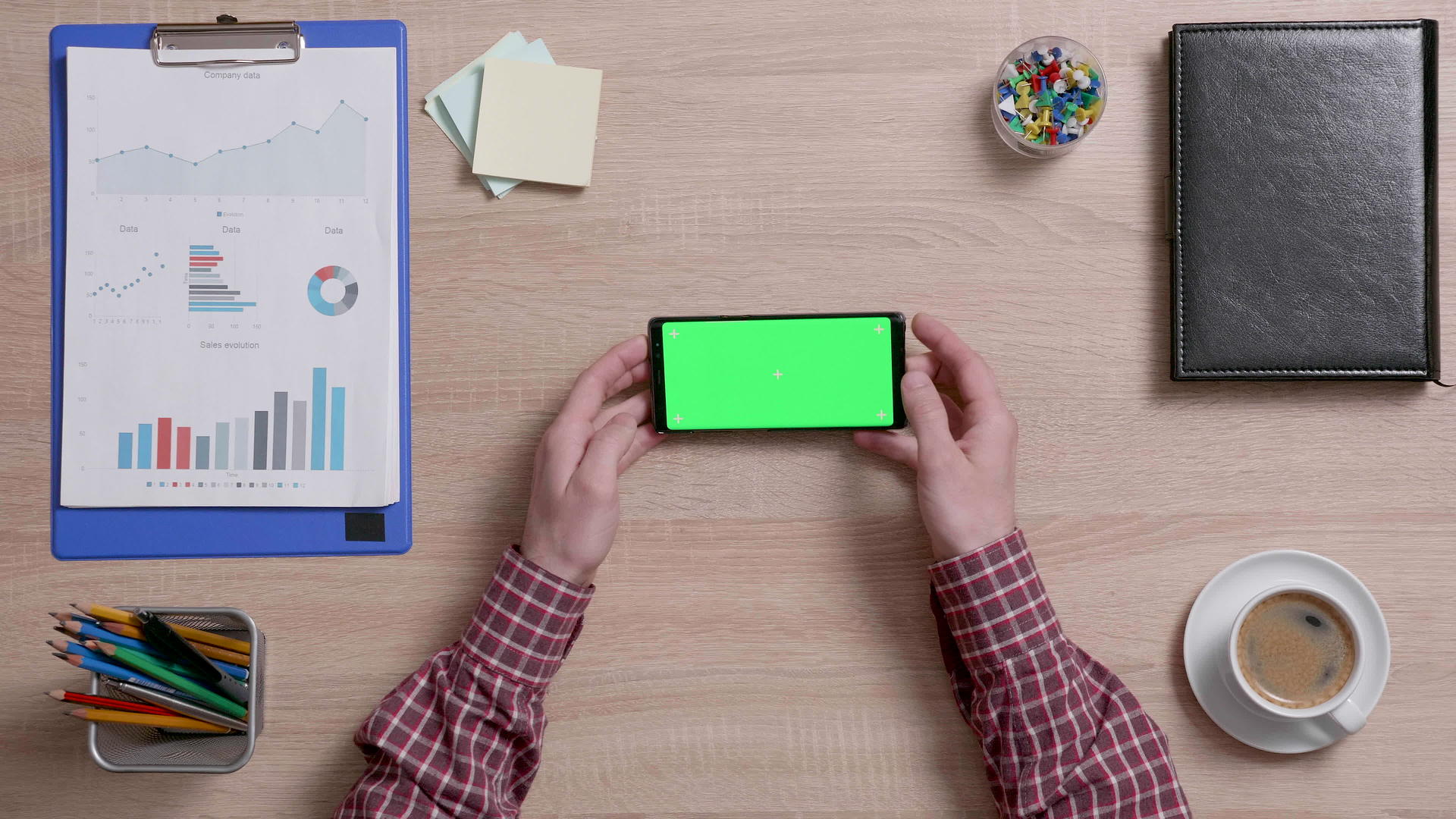 男人用绿色屏幕拿着智能手机的书桌视频的预览图