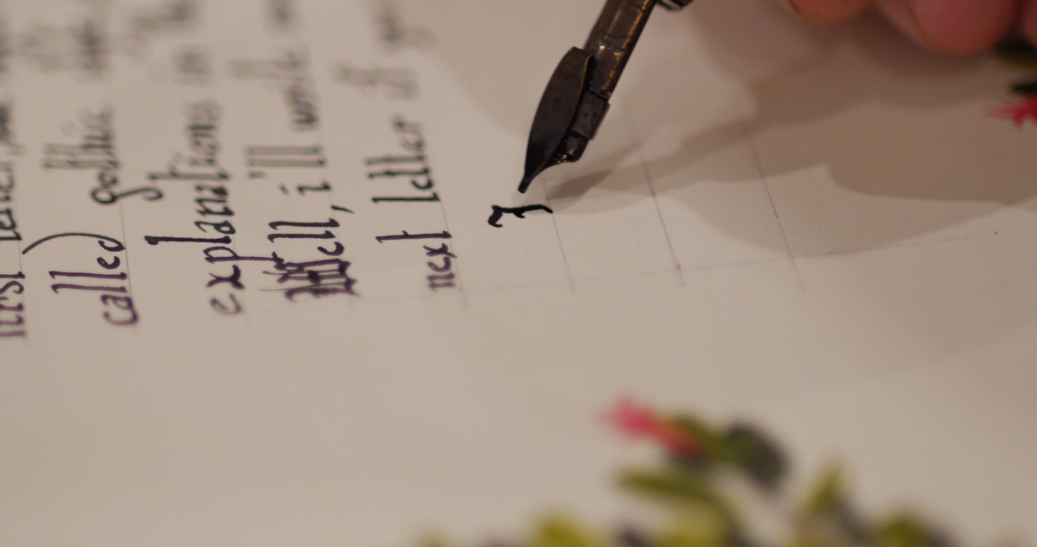 男人用书法哥特式字母写一封装饰信男人用笔尖和墨水写字视频的预览图