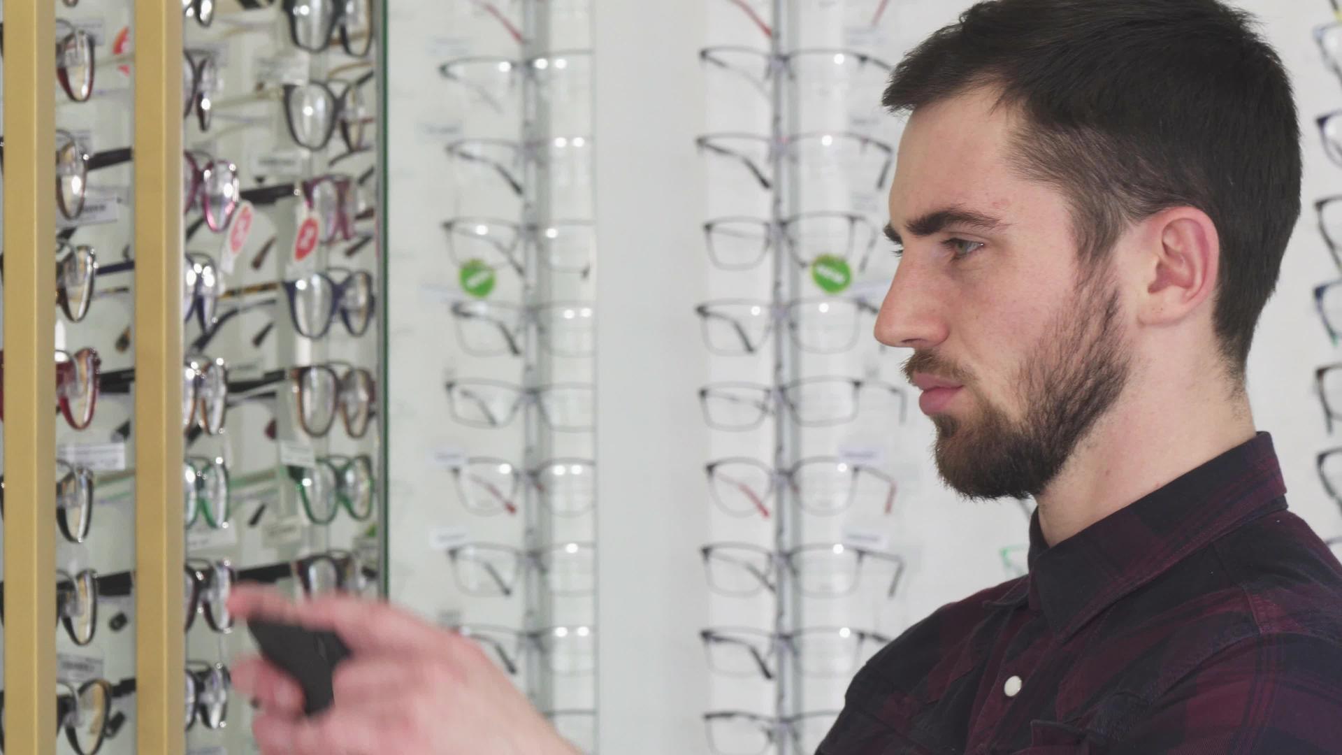 年轻男子在眼罩店拍摄眼镜照片视频的预览图