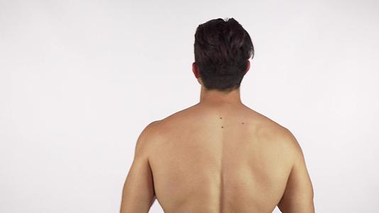 背部和手臂肌肉伸展的肌肉上没有衬衫男子的后视镜头视频的预览图