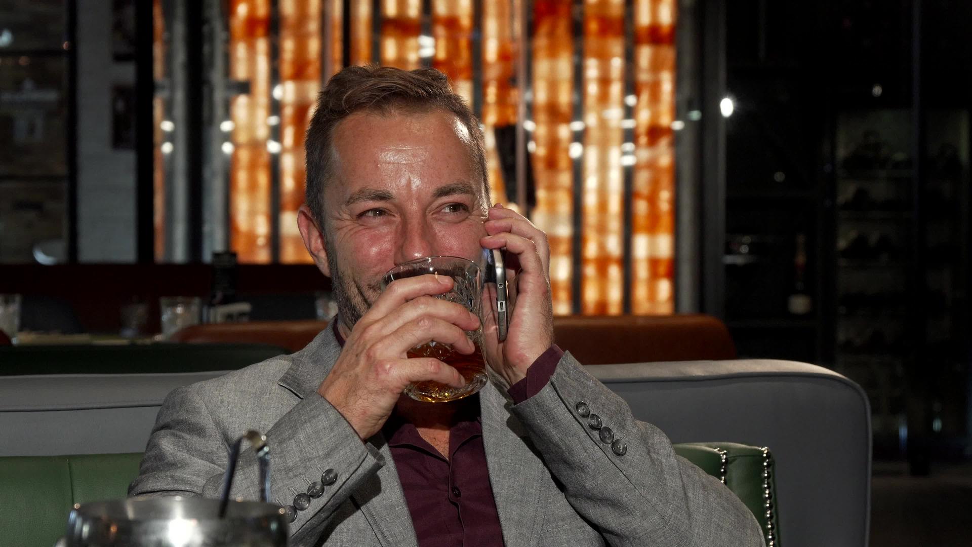 快乐的商人在电话里聊天时喝威士忌视频的预览图
