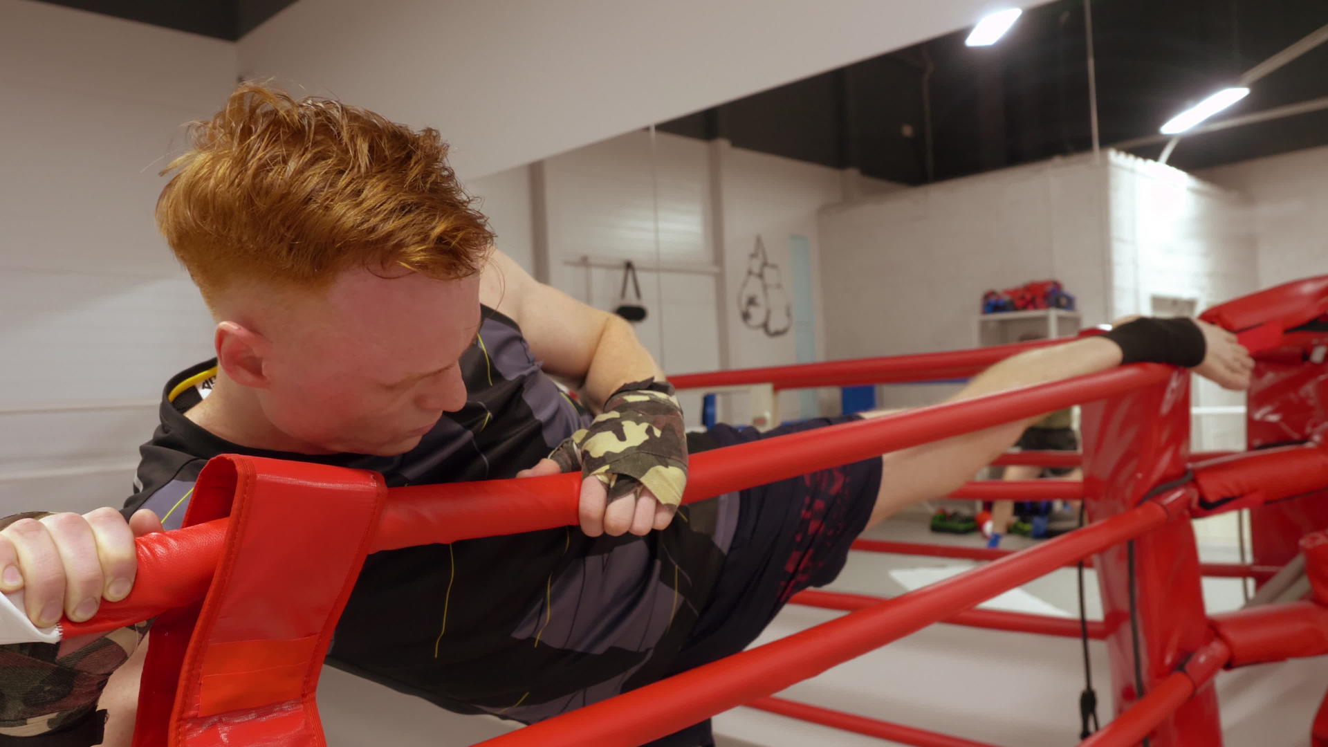 男拳击手在拳击俱乐部拳击训练前伸展双腿视频的预览图