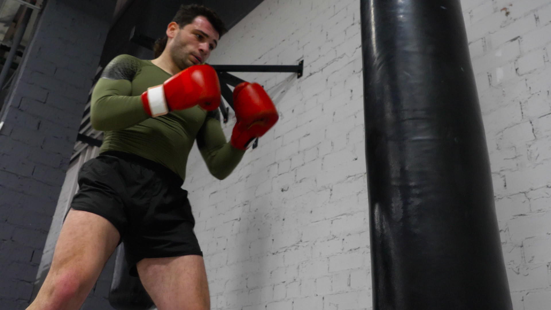 拳击手在体育场训练用拳击背包踢和练习拳击视频的预览图