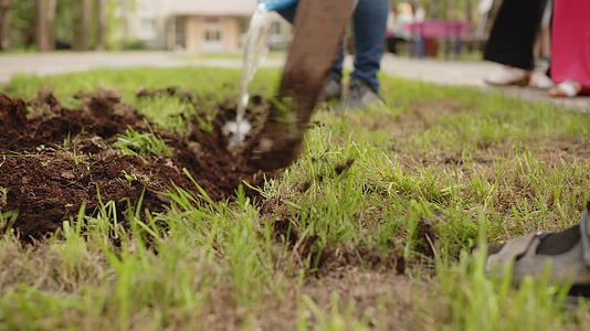 男子用铲子在花坛上挖土在花坛上挖草坪种植园艺和园林绿化视频的预览图