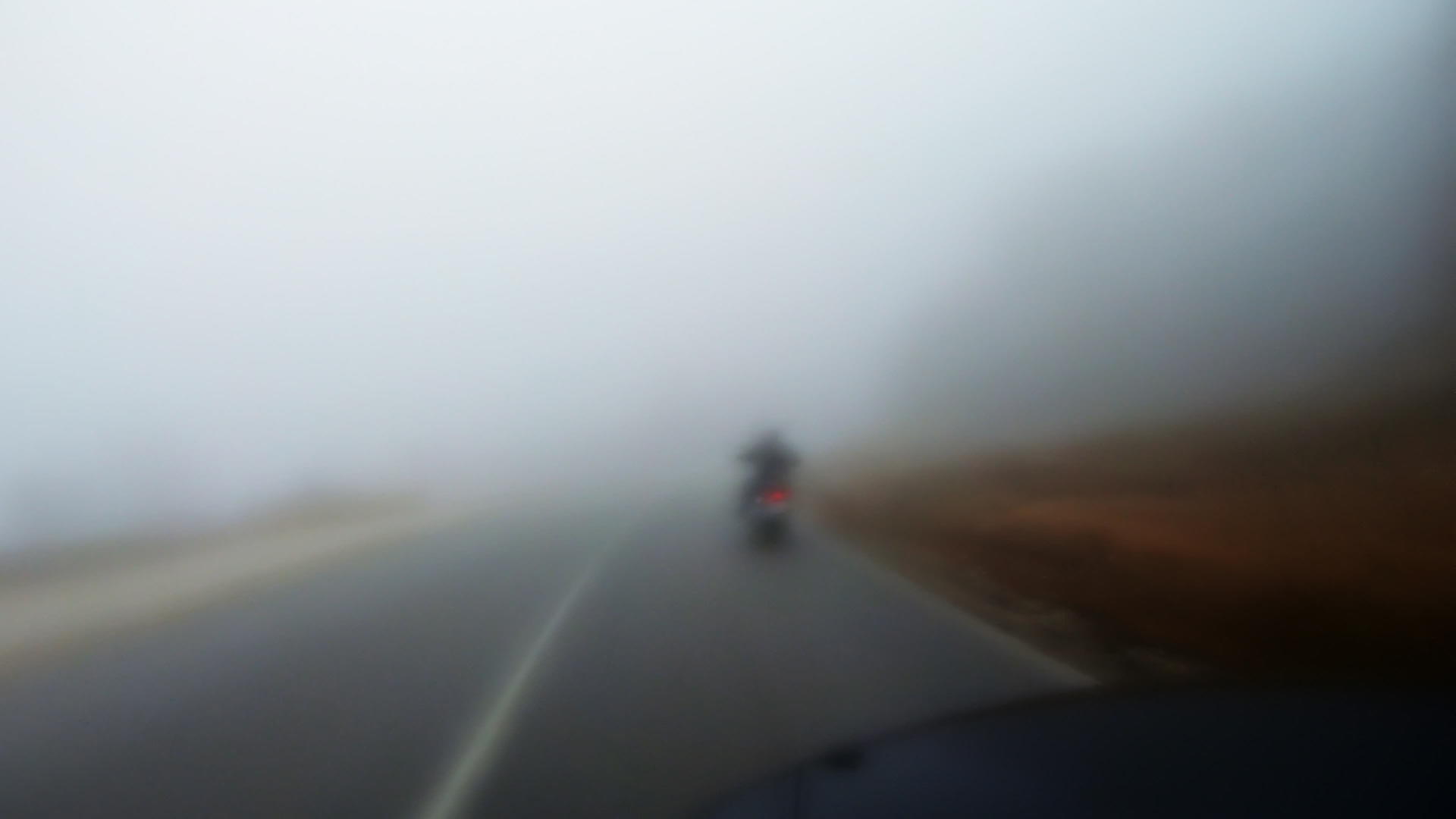 在路上骑摩托车穿过雾蒙蒙的摩托车视频的预览图