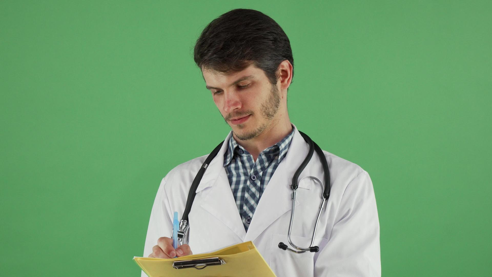 年轻的男医生在他的绿色铬染色体剪贴板上写字视频的预览图