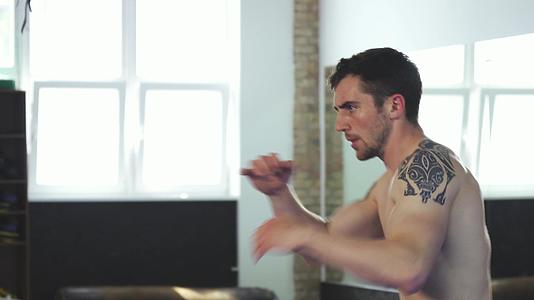 强壮的肌肉男拳击手在健身房练习拳击视频的预览图
