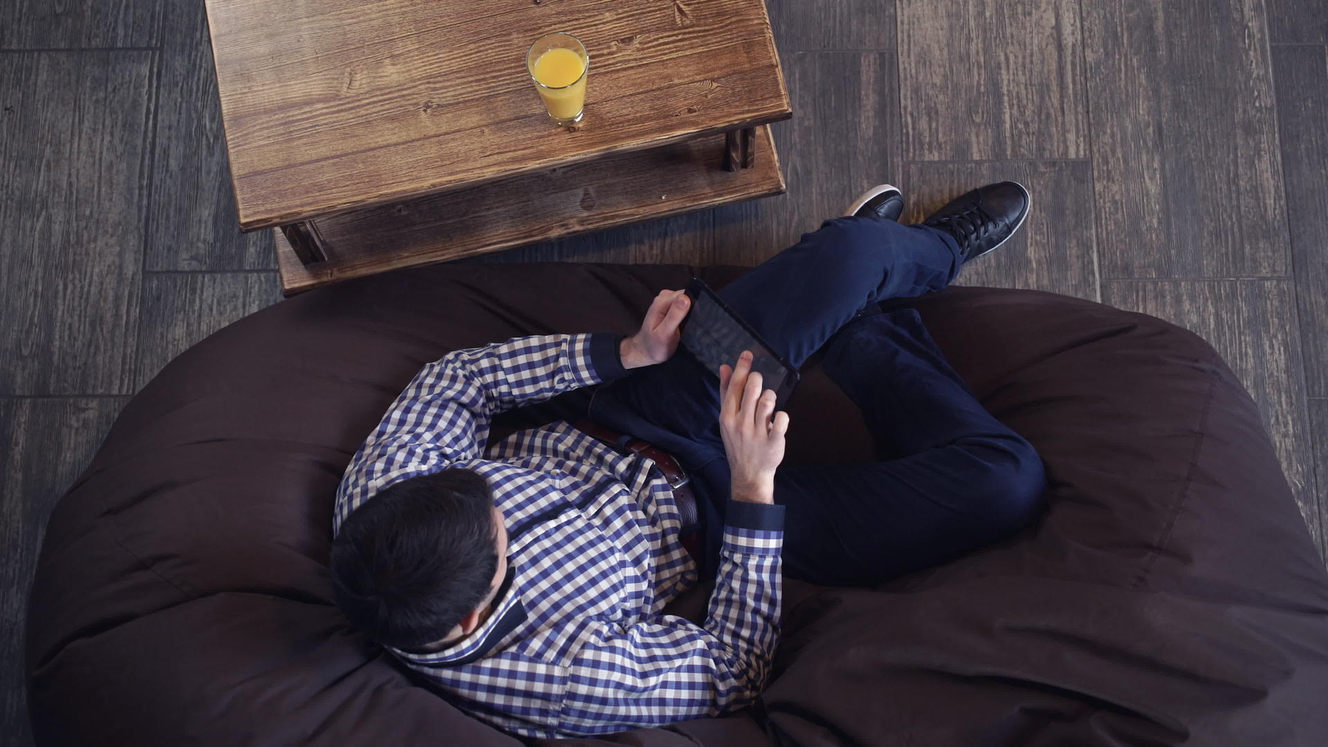 一个穿着衬衫的迷人男人躺在石板椅上的椅子上视频的预览图
