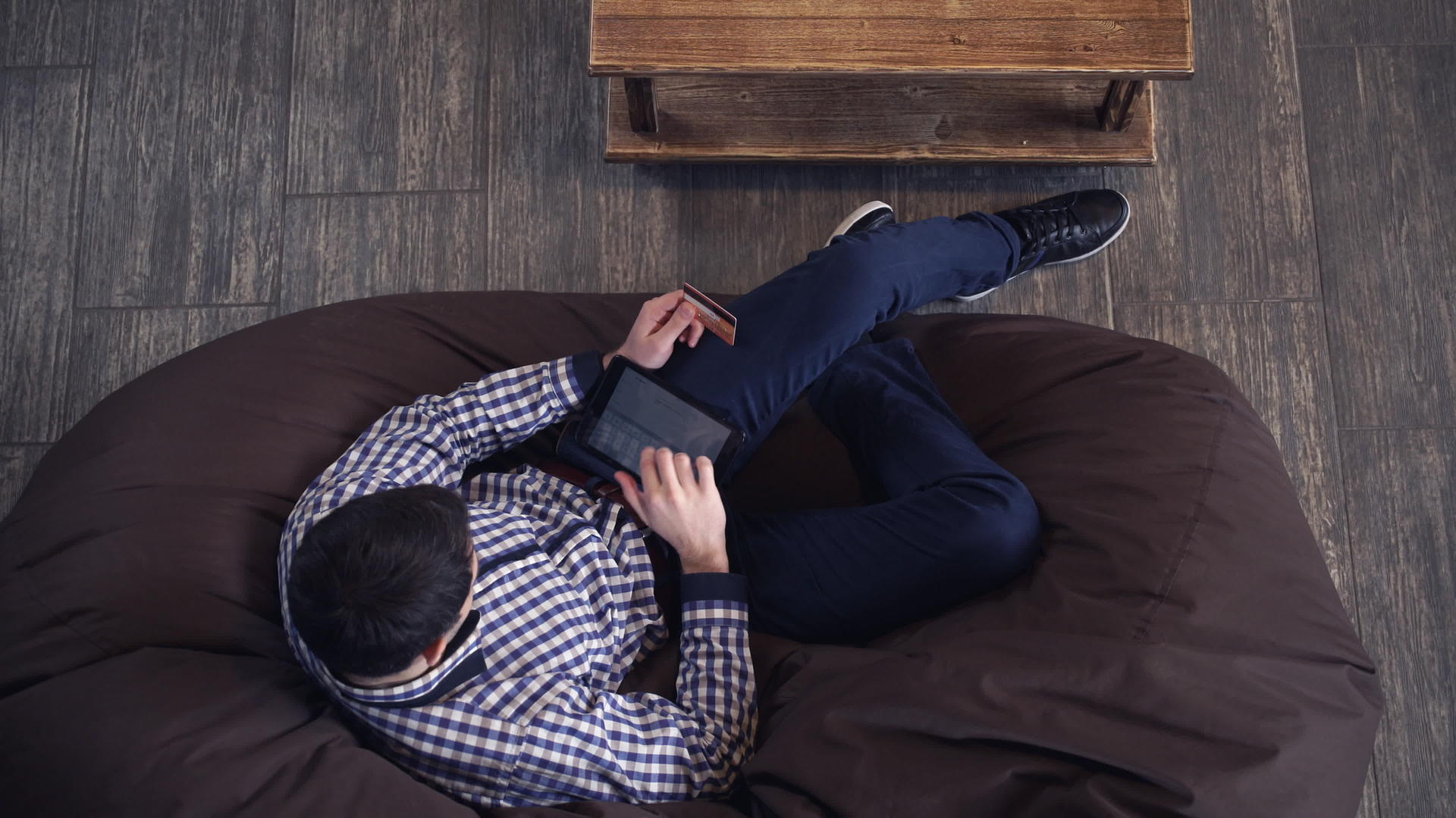 男人用钢笔和信用卡支付躺在椅子上的账单视频的预览图