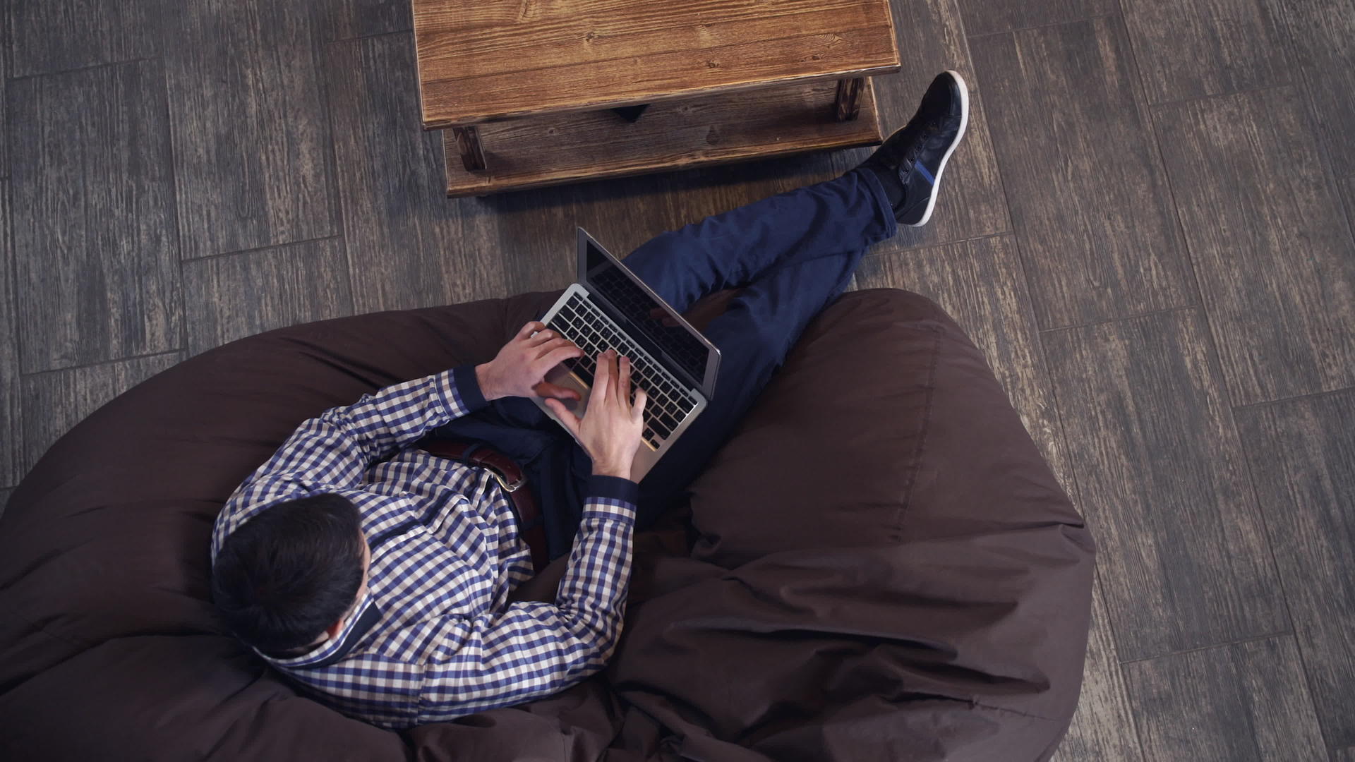 男子拿着笔记本电脑躺在扶手椅上打字视频的预览图