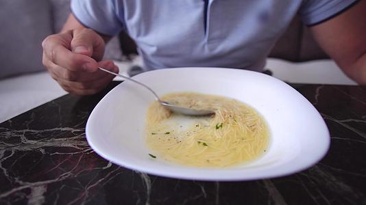 男人在餐桌上吃美味的汤视频的预览图