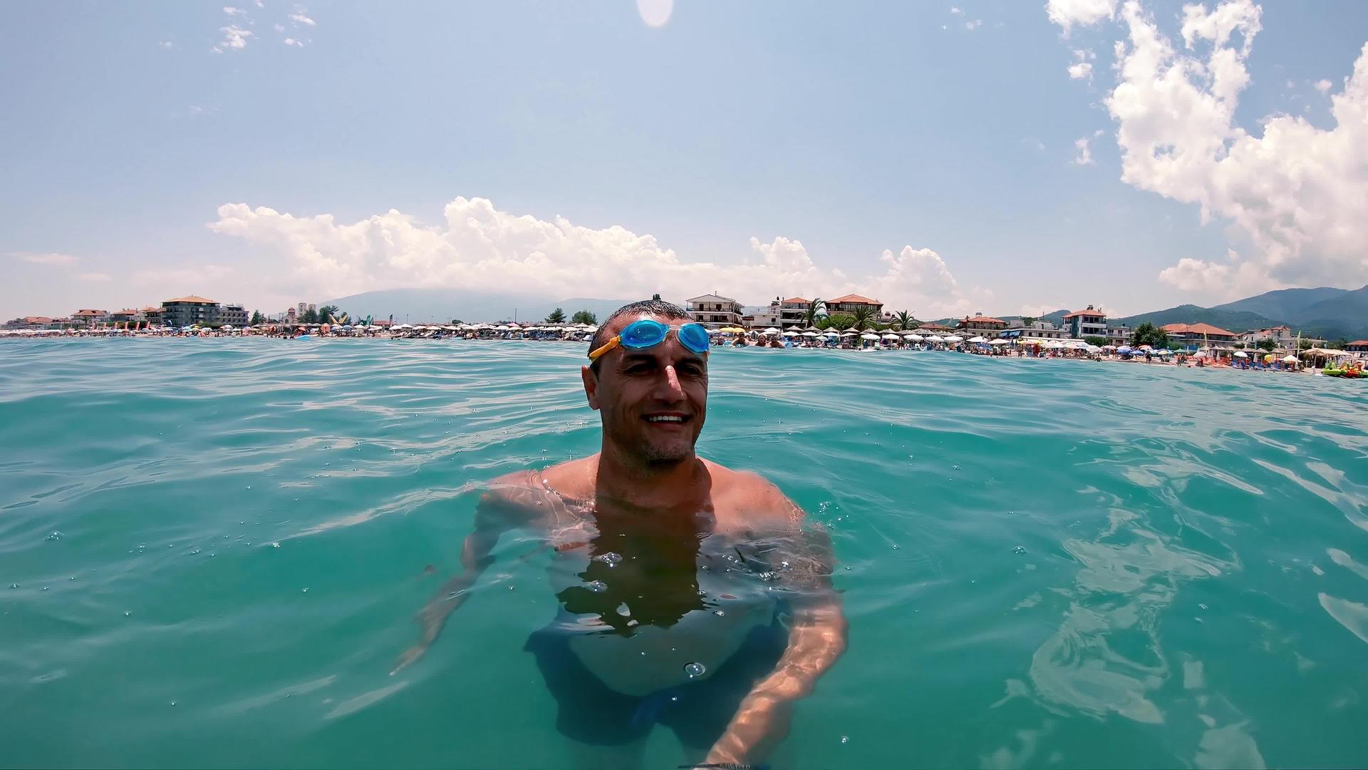 快乐的男人在海里游泳和潜水时戴着护目镜视频的预览图