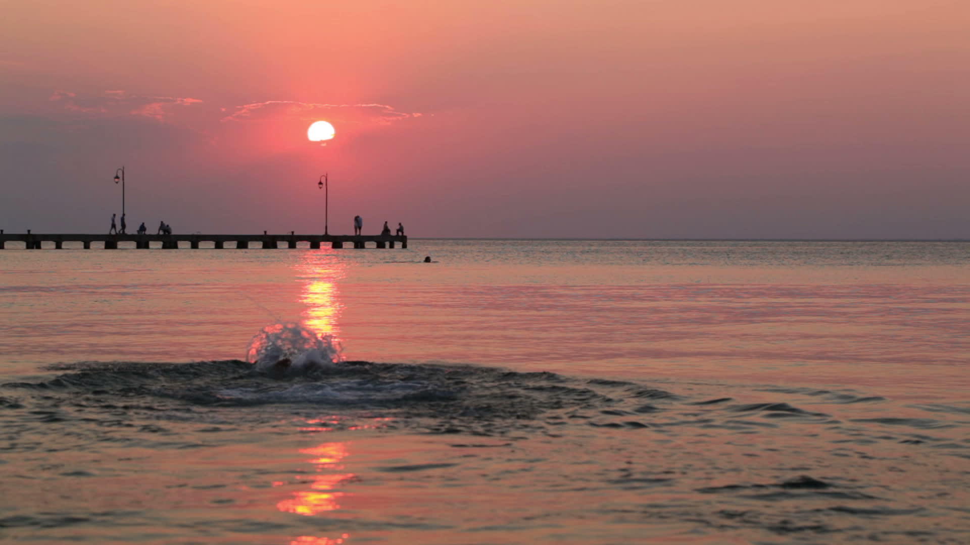 日落时在海里游泳的人视频的预览图