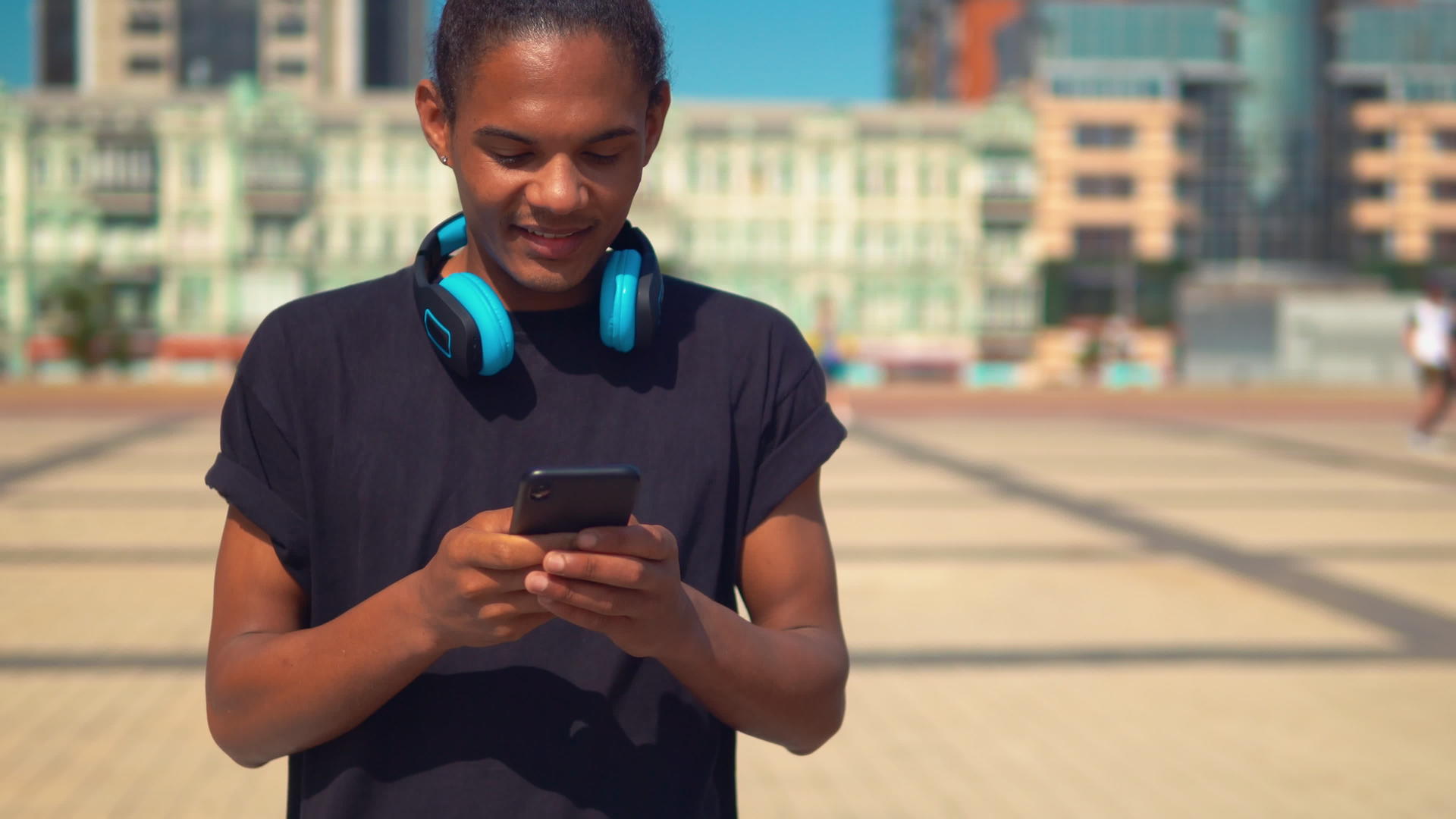 快乐的年轻人在街上使用智能手机应用程序视频的预览图