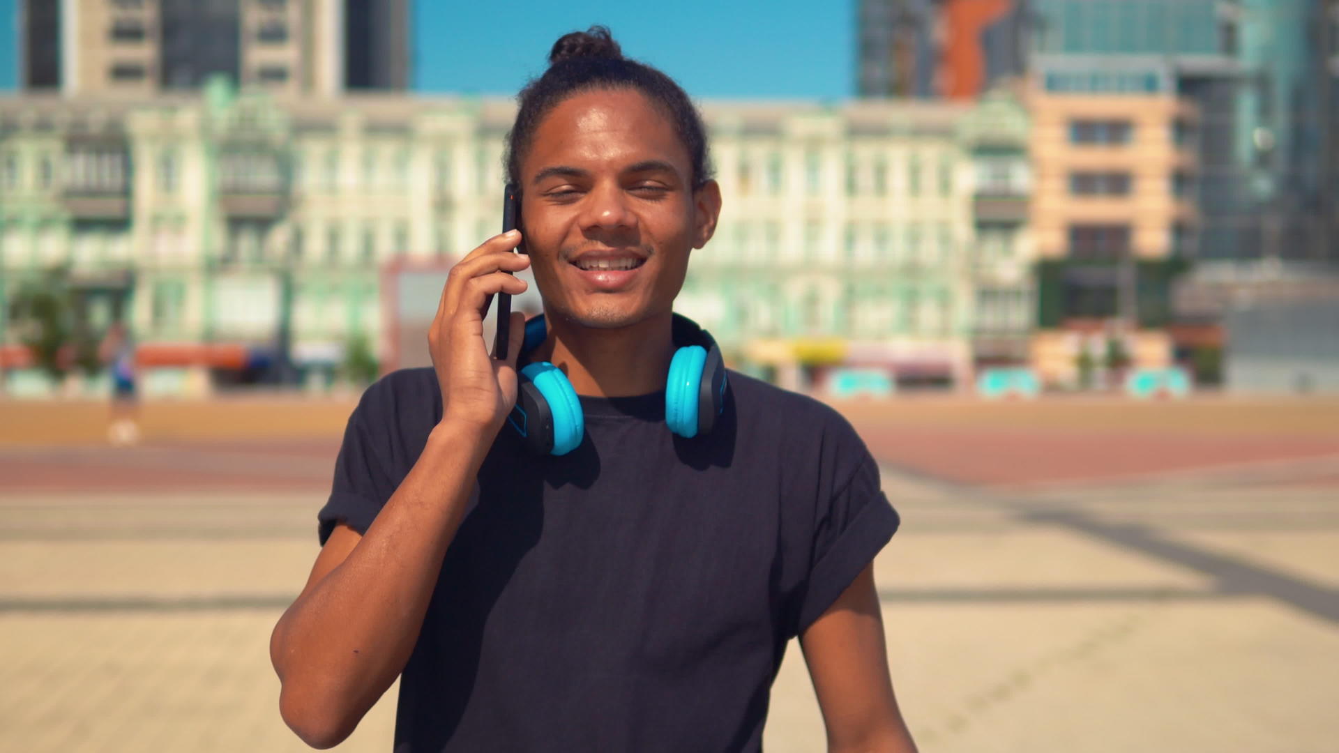 快乐的年轻人通过电话在街上行走视频的预览图
