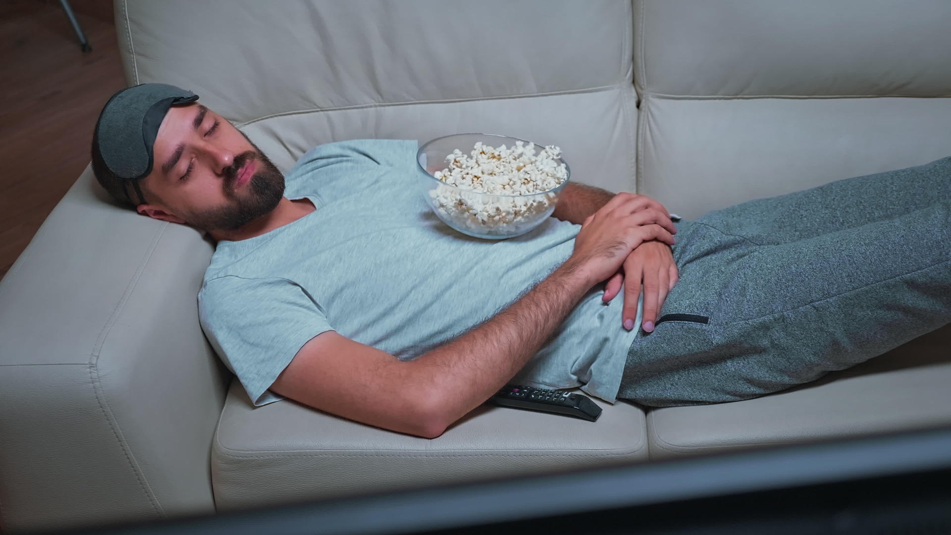 男人躺在沙发上看电影视频的预览图