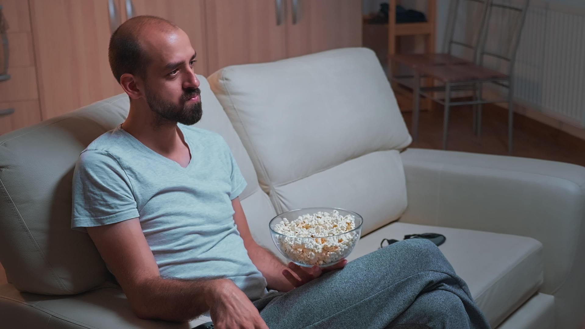 男人在沙发上很冷看电影系列的时候他们手里拿着一个爆米花碗视频的预览图