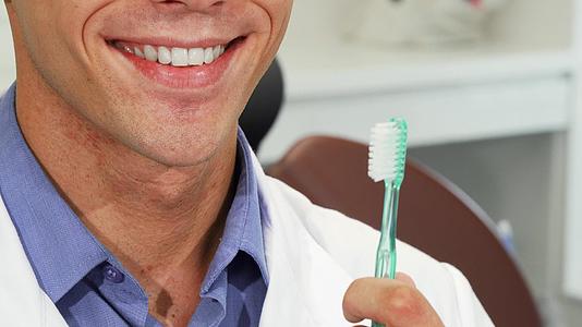 男性牙医用牙刷微笑着完美的牙齿视频的预览图