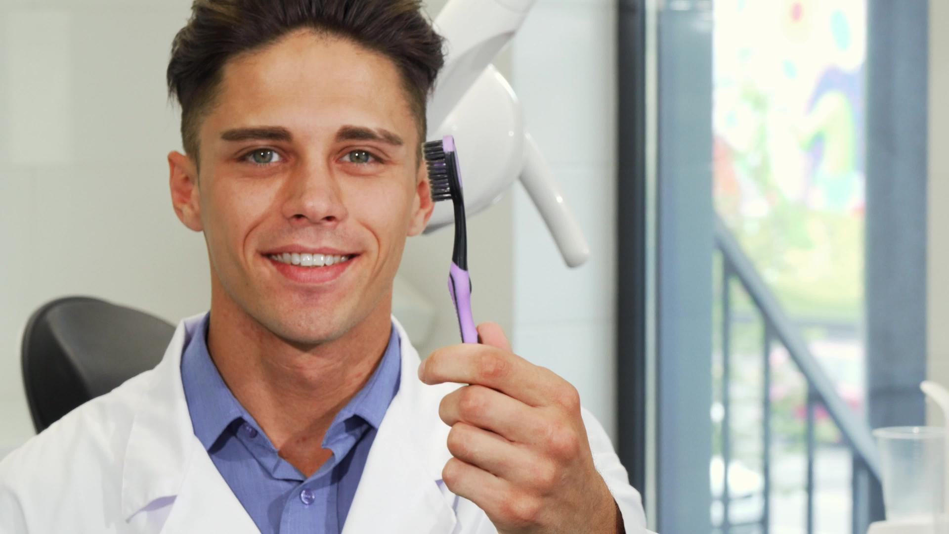 吸引人的男性牙医用牙刷微笑视频的预览图