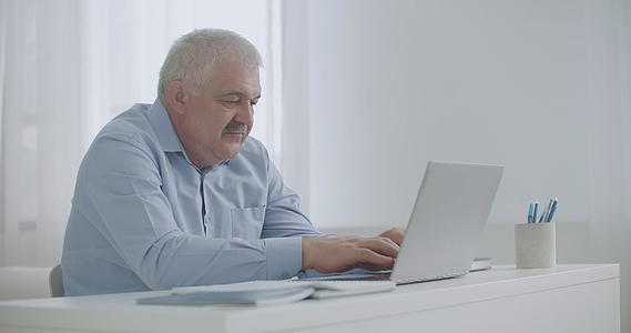 中年男子正在使用笔记本电脑技术和互联网联网打字信息视频的预览图