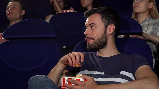 在电影院无聊的电影影院无聊的电影里吃爆米花视频的预览图