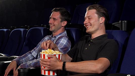 两个男性朋友在电影院看喜剧时笑了视频的预览图