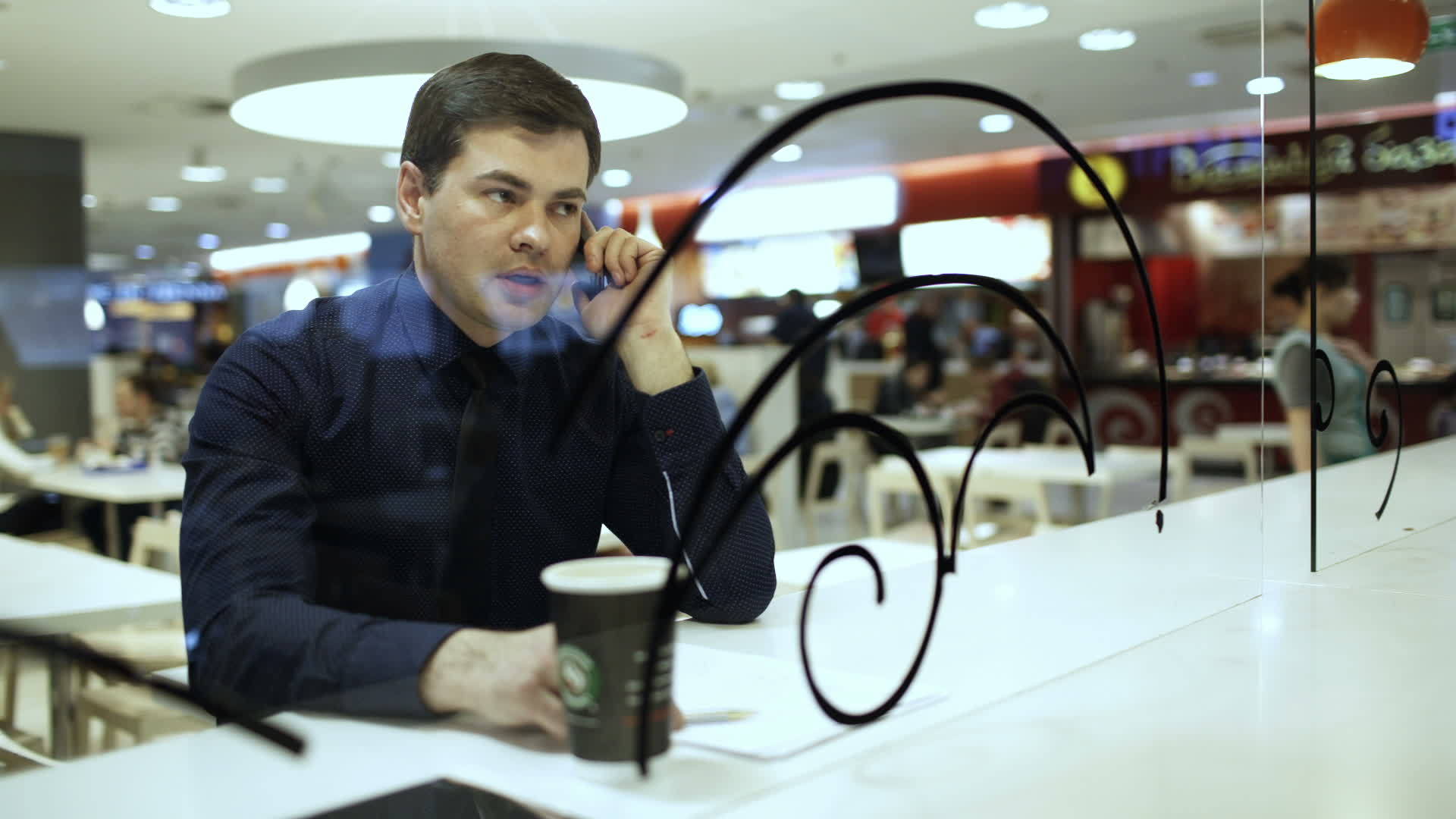商人在咖啡馆里通过电话交谈视频的预览图
