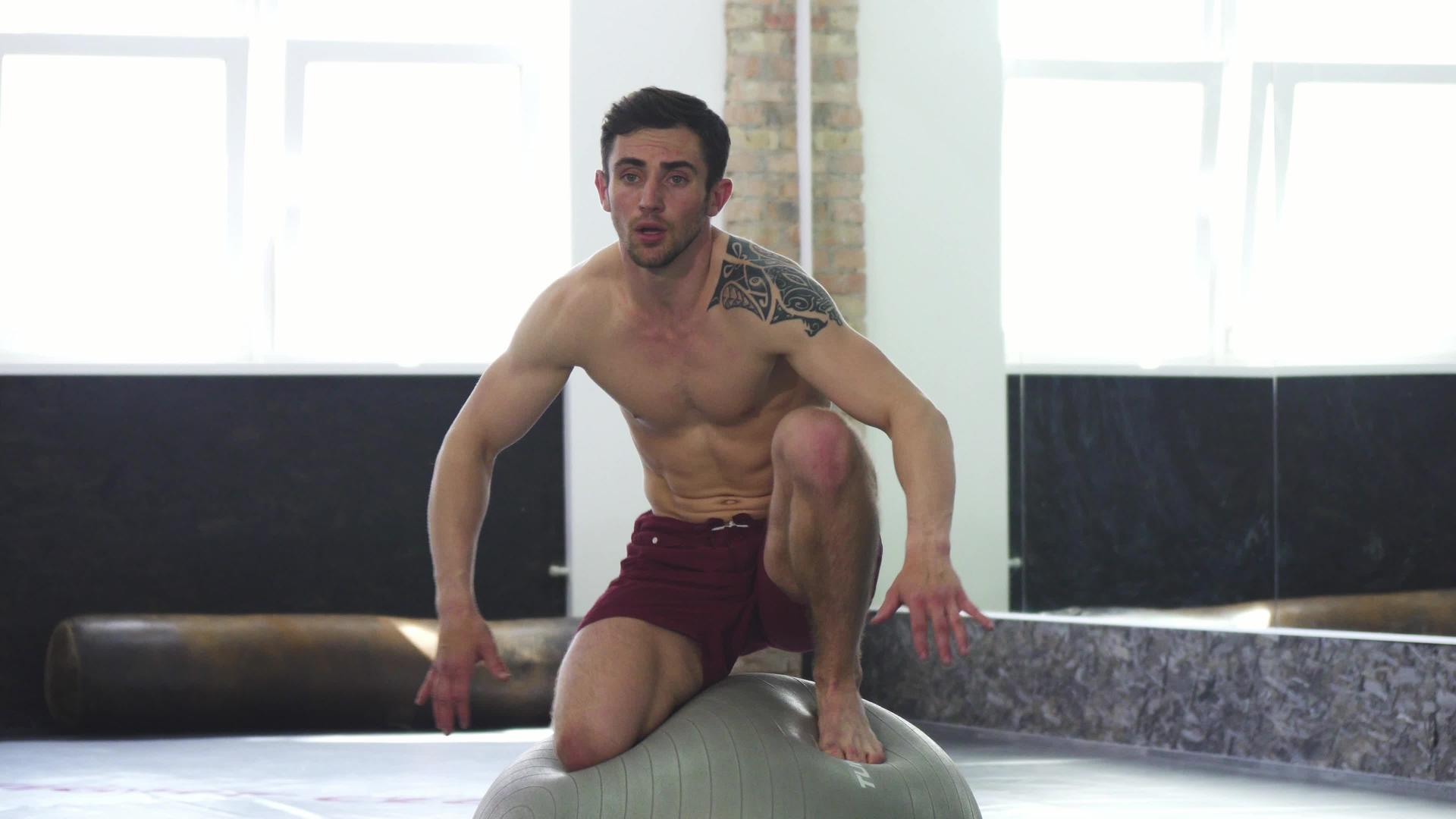 年轻英俊的男运动员在健身球上平衡视频的预览图