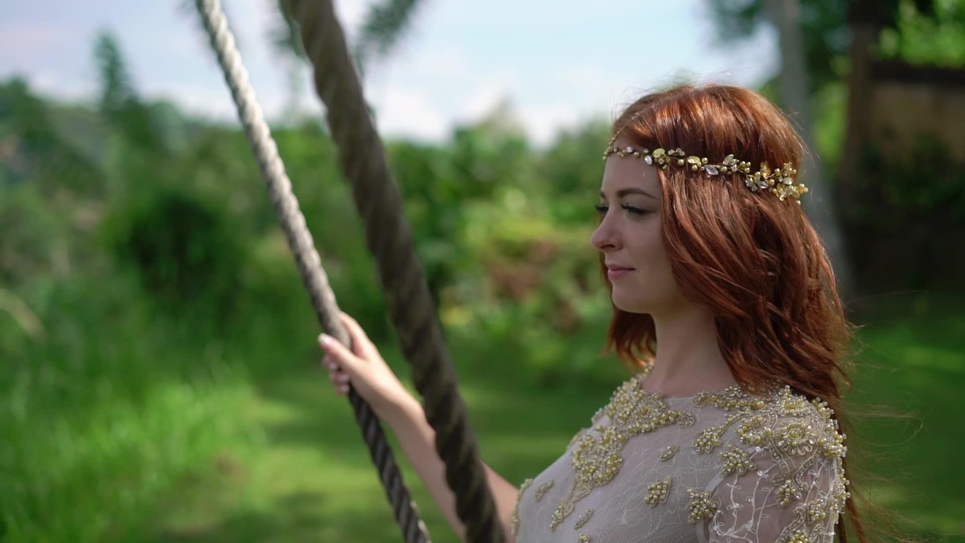 一个年轻女子在悬崖上挥舞着Bali婚礼上的秋千视频的预览图