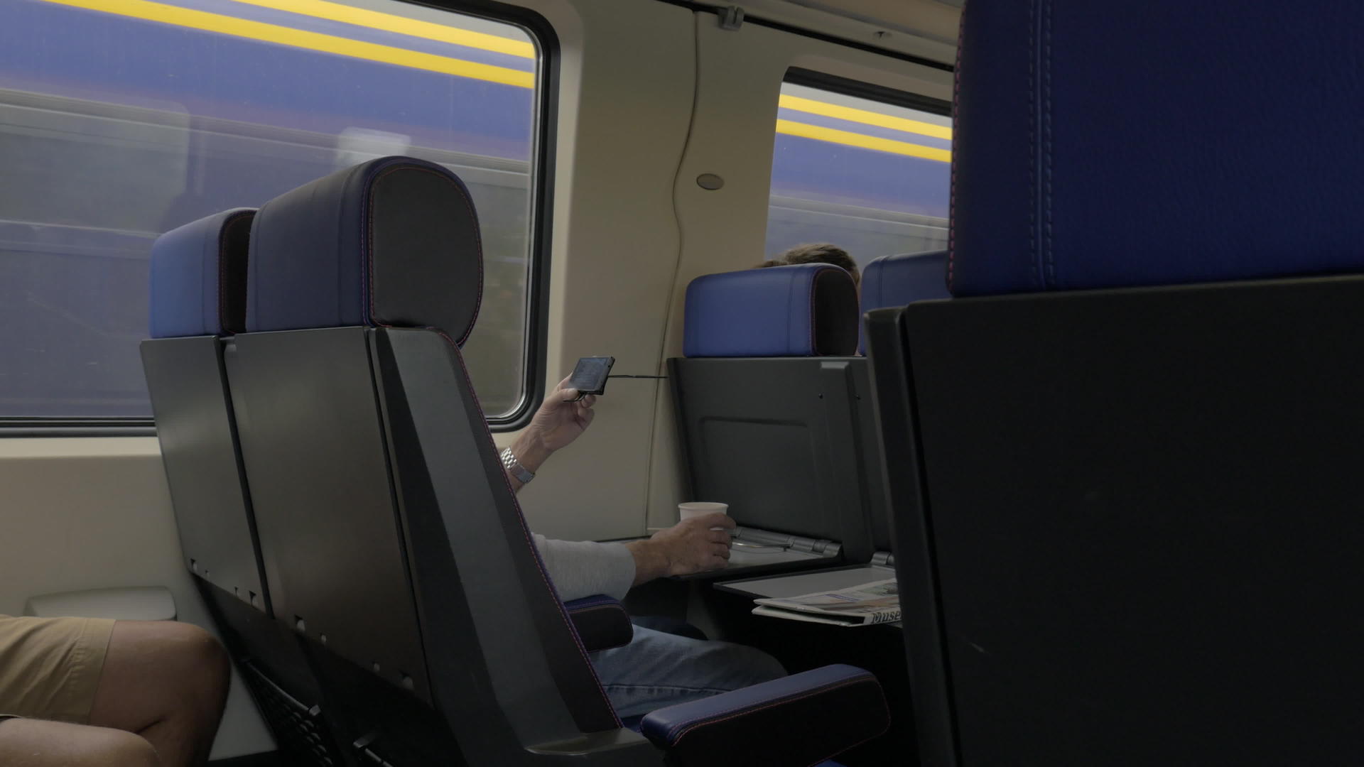 坐在火车上用笔记本电脑在桌子上工作在窗边喝酒视频的预览图