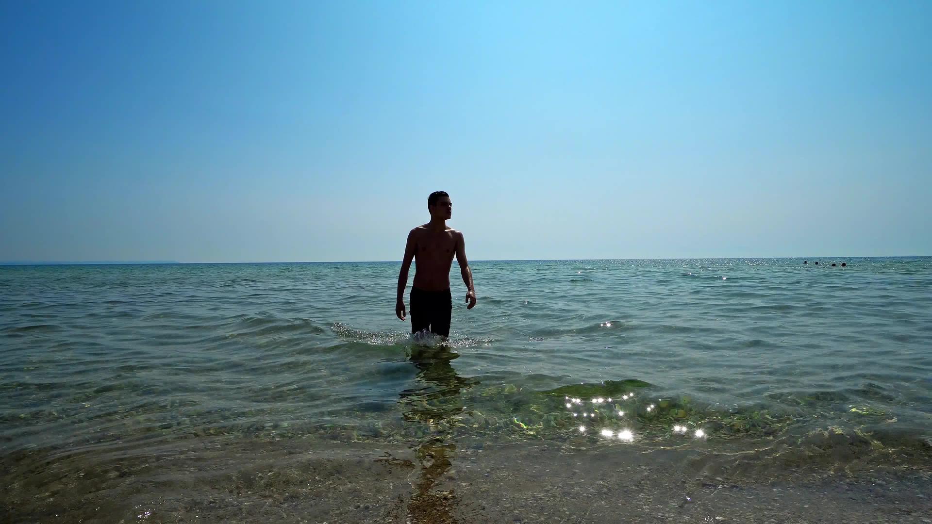 英俊的运动员和男性在海边走出水面Standicam视频的预览图