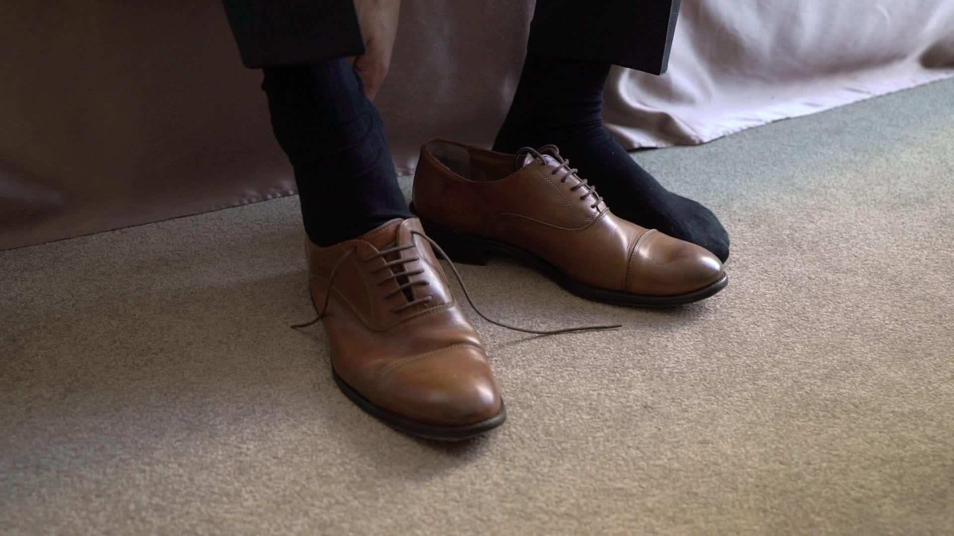 年轻男子穿上鞋子庆祝商务会议或婚礼视频的预览图