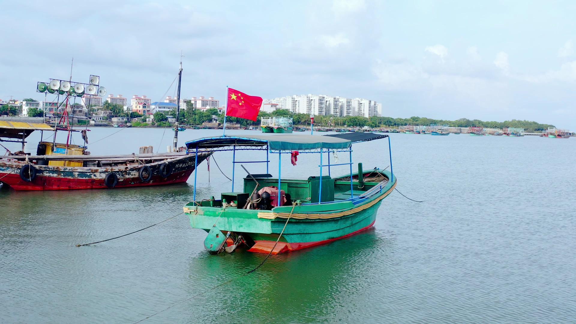 4K航拍停在海边的渔船国旗红旗飘飘视频素材视频的预览图