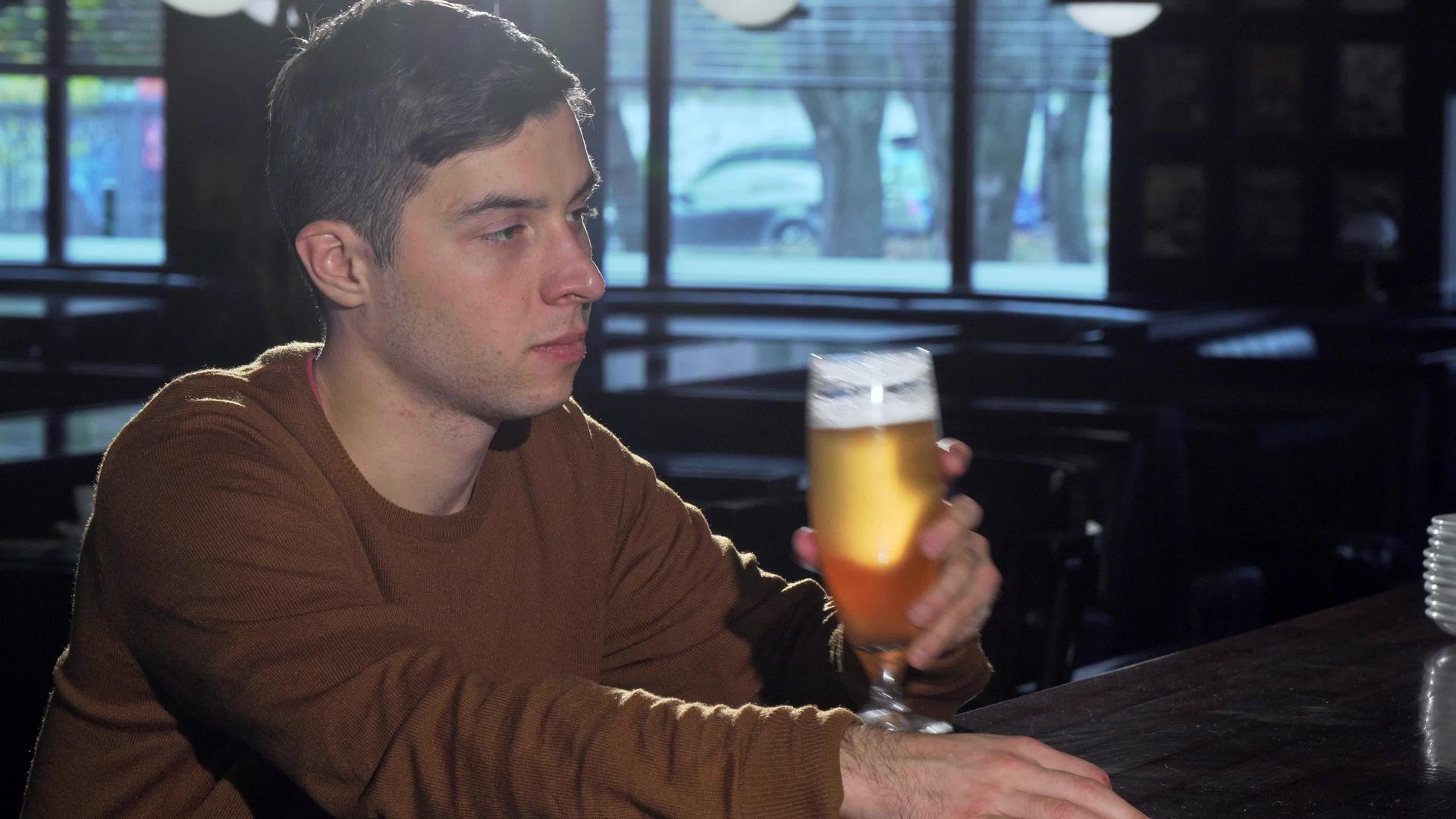 喝了杯里美味的啤酒后年轻人对着相机微笑视频的预览图