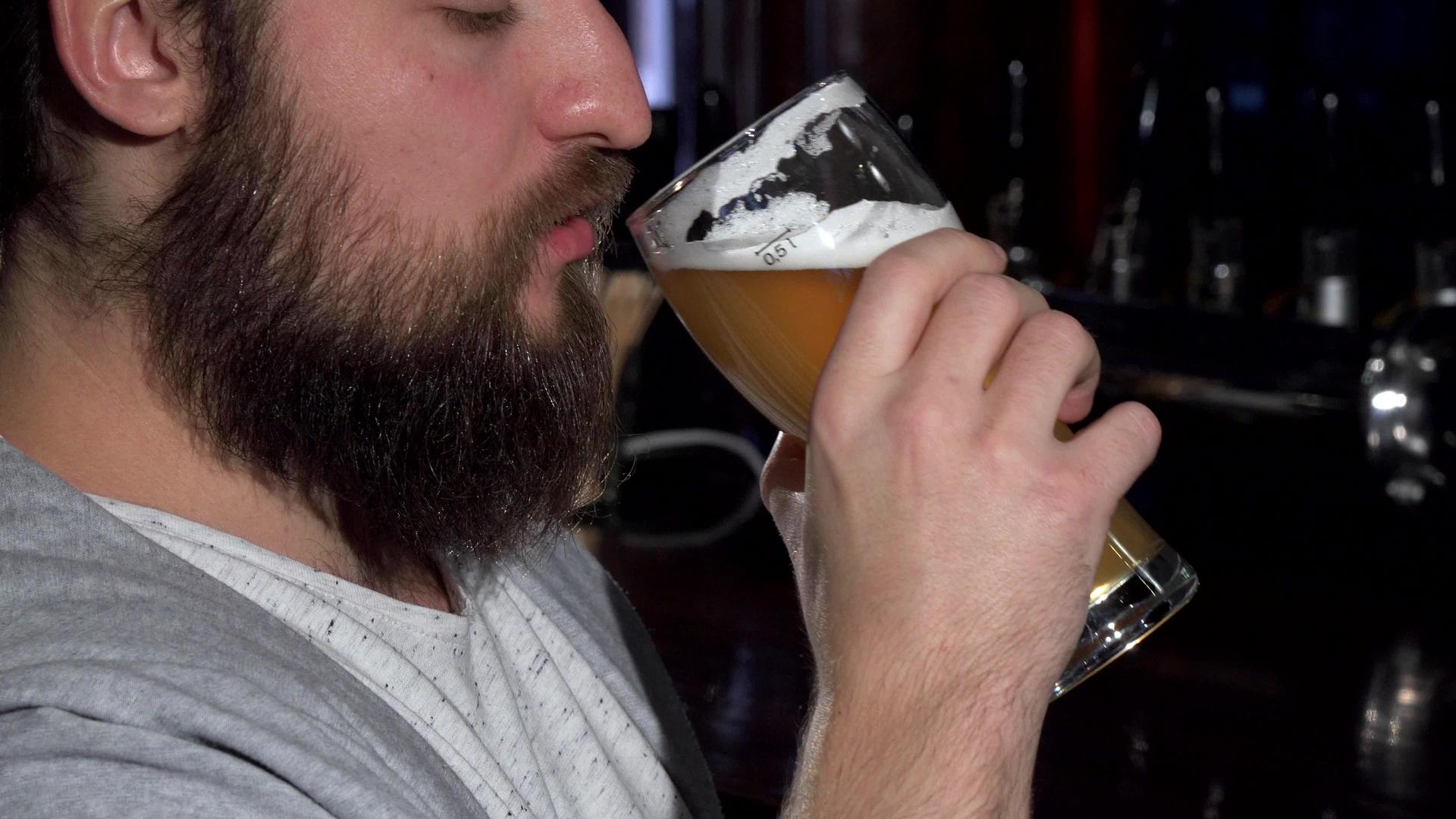 在酒吧里喝了美味的啤酒后长胡子的男人微笑着视频的预览图