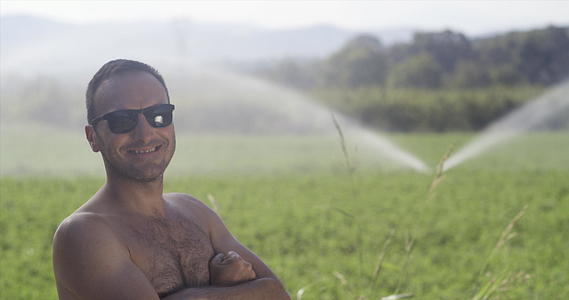 在有灌溉系统的绿地上农业工人没有衬衫也没有衬衫背景视频的预览图