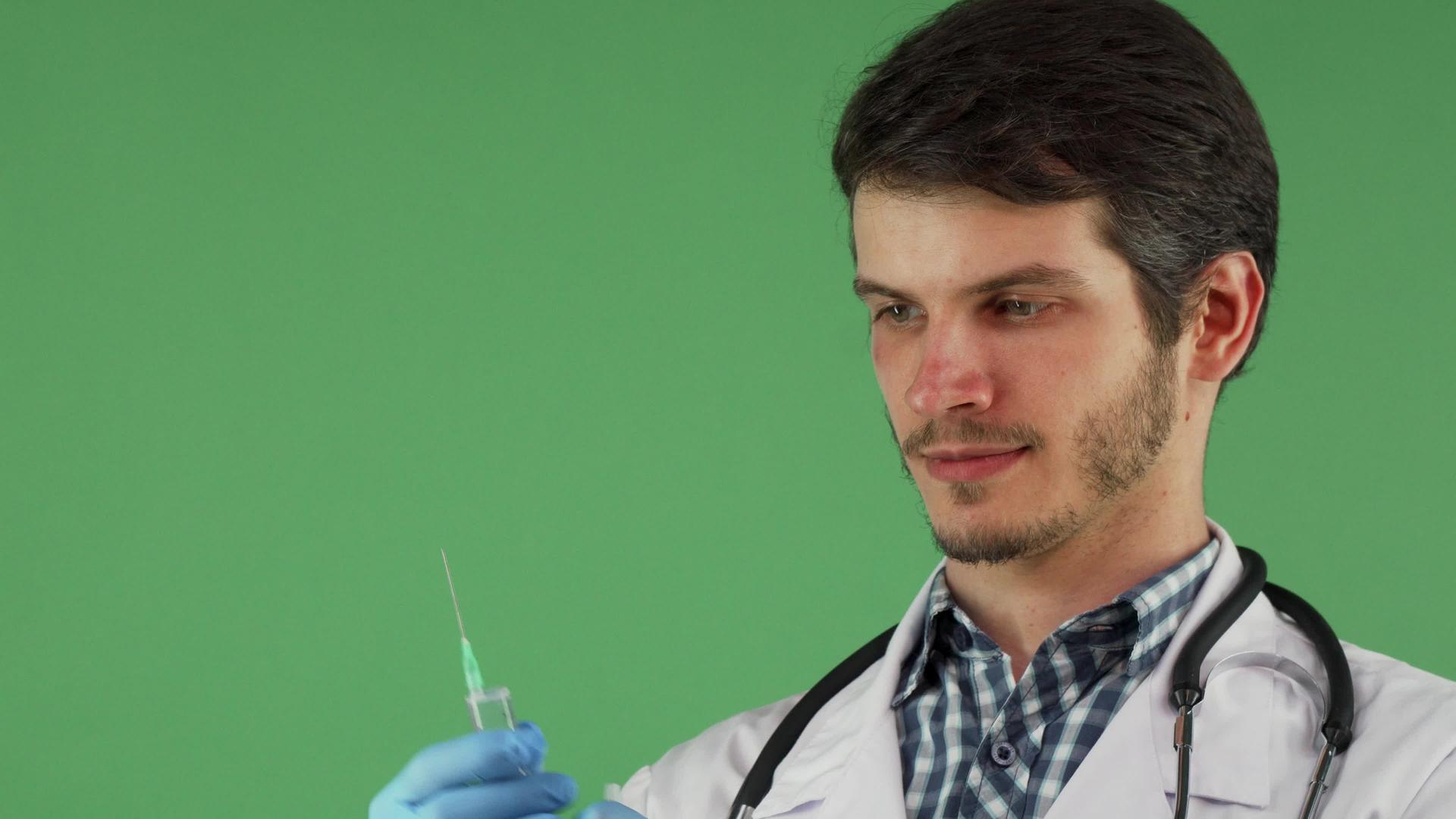男医务工作者持有绿色背景注射针视频的预览图