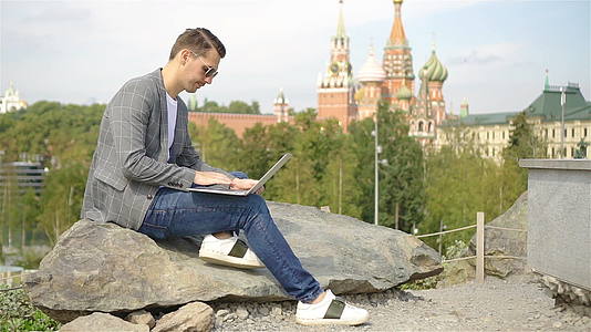 男人在公园休息时用笔记本电脑工作视频的预览图