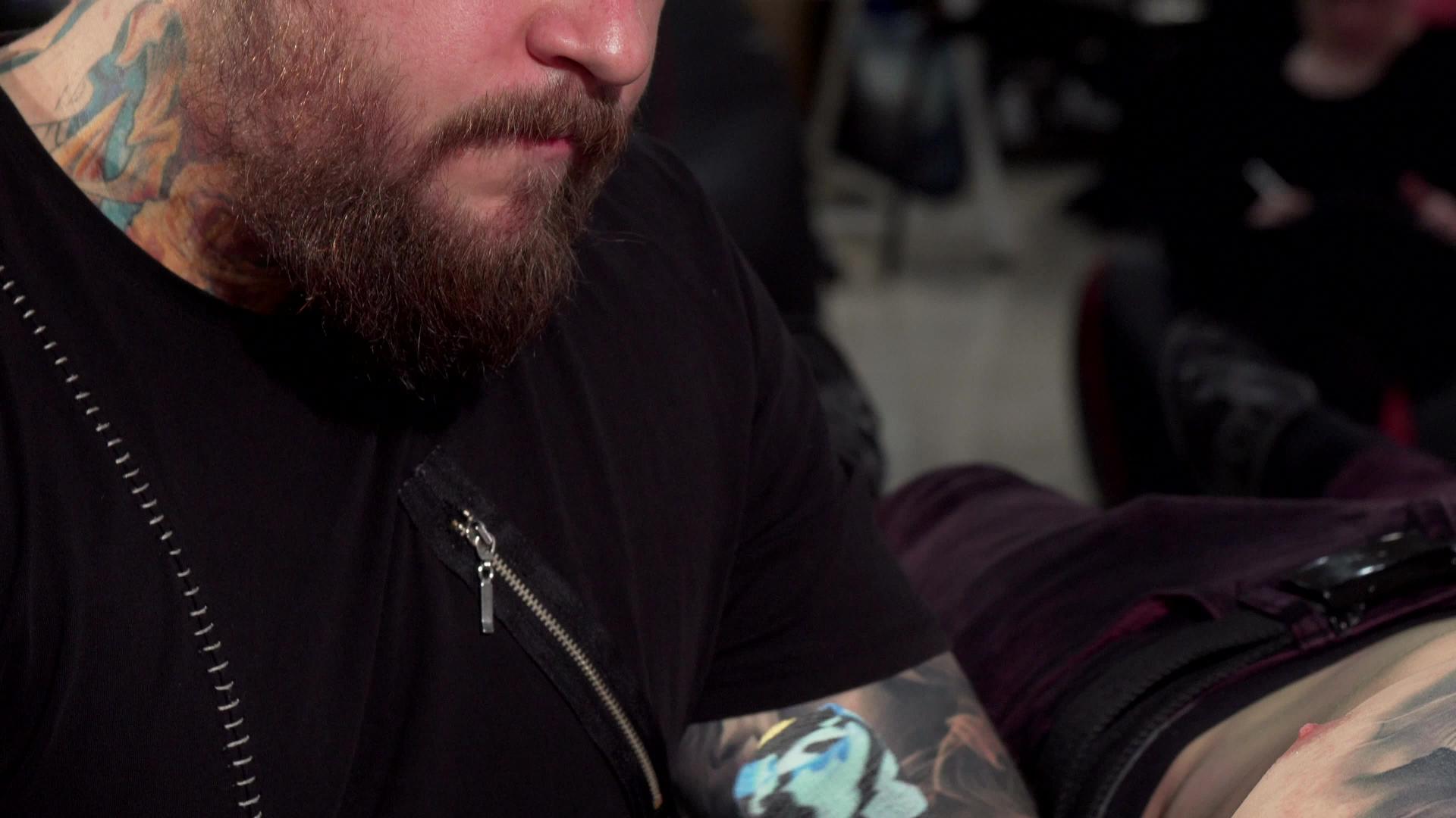 专业纹身艺术家在纹身店工作的滑动镜头视频的预览图