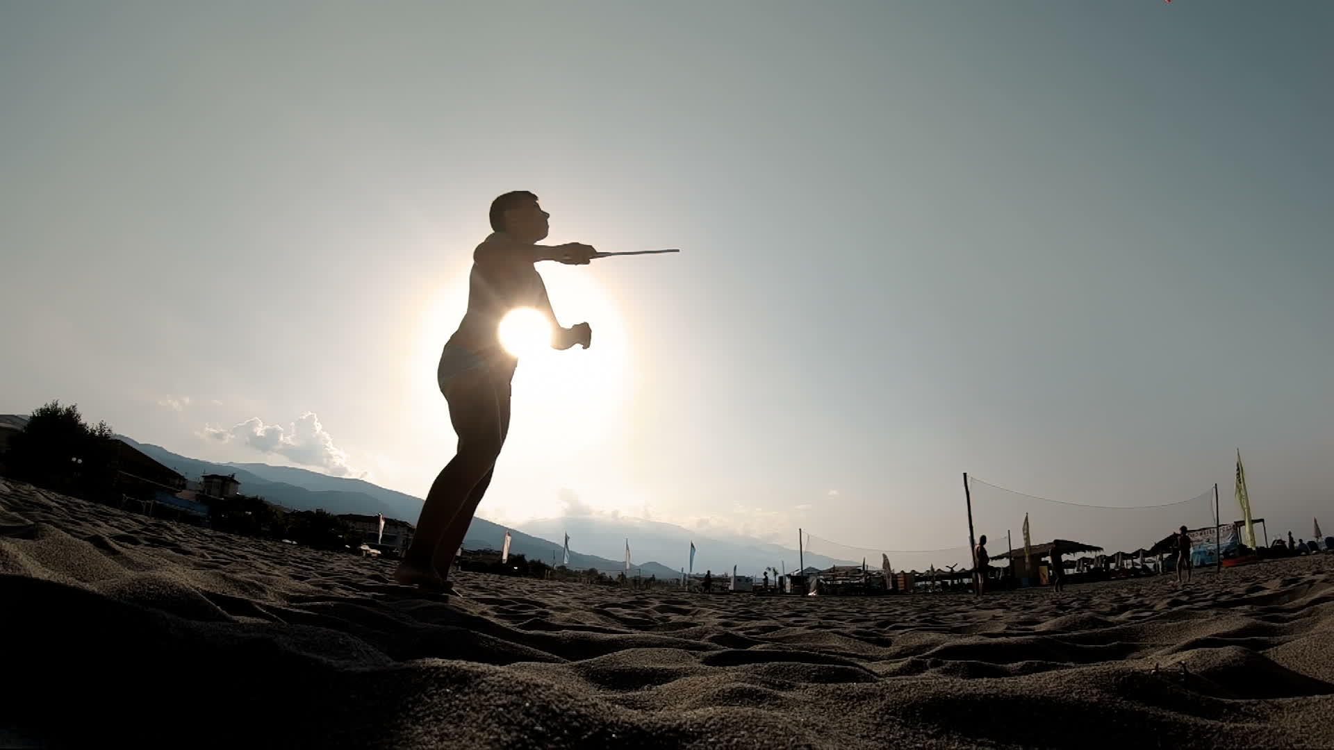 年轻人在岸边玩划桨球在沙滩上慢动作视频的预览图