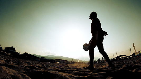 男人在沙滩上打网球的轮廓视频的预览图