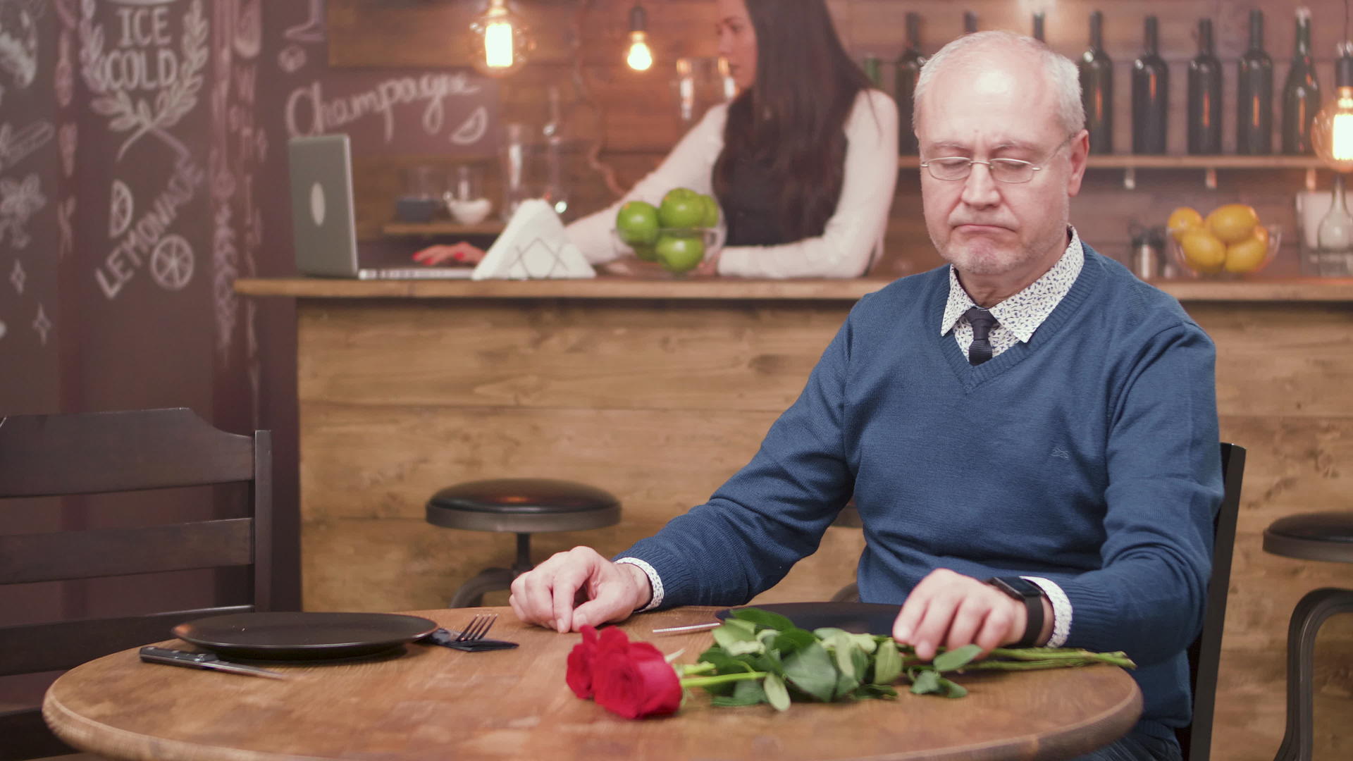 悲伤的老人坐在餐厅的餐桌旁等待他的约会视频的预览图