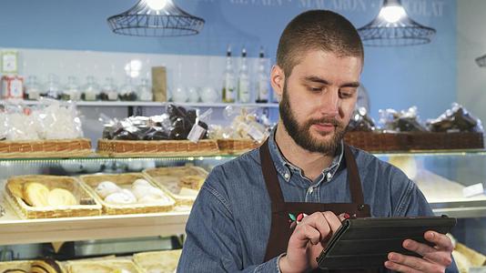 英俊的男士专业面包师在商店里使用数字平板纸视频的预览图
