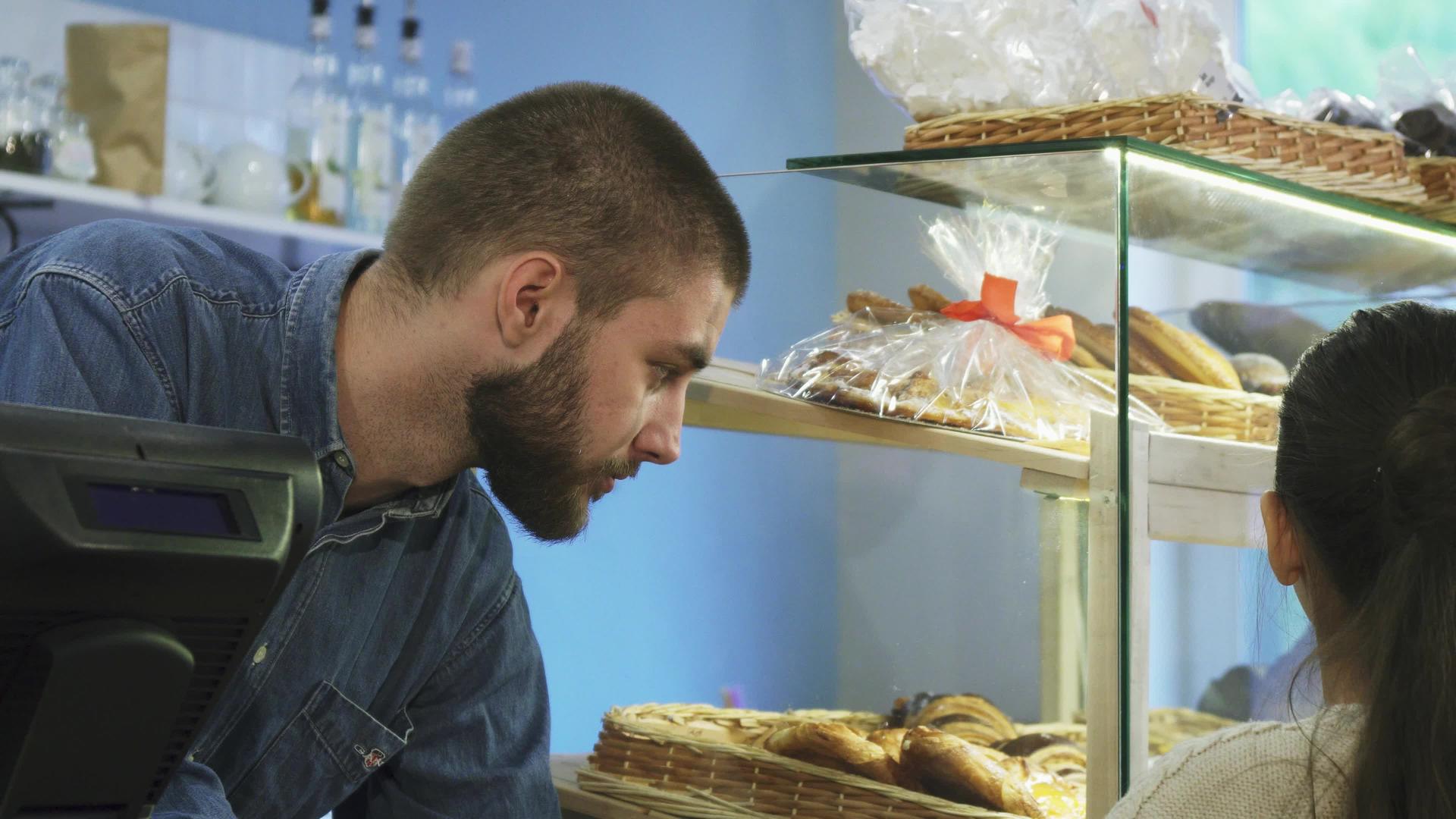 吸引人的男面包师在面包店和一个小女孩说话视频的预览图