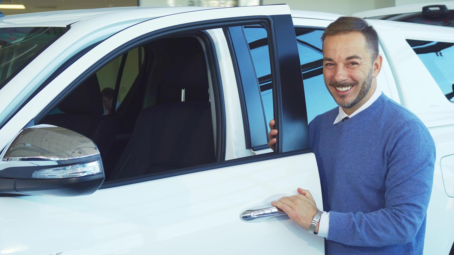 一个微笑的人打开了他的新车的门视频的预览图