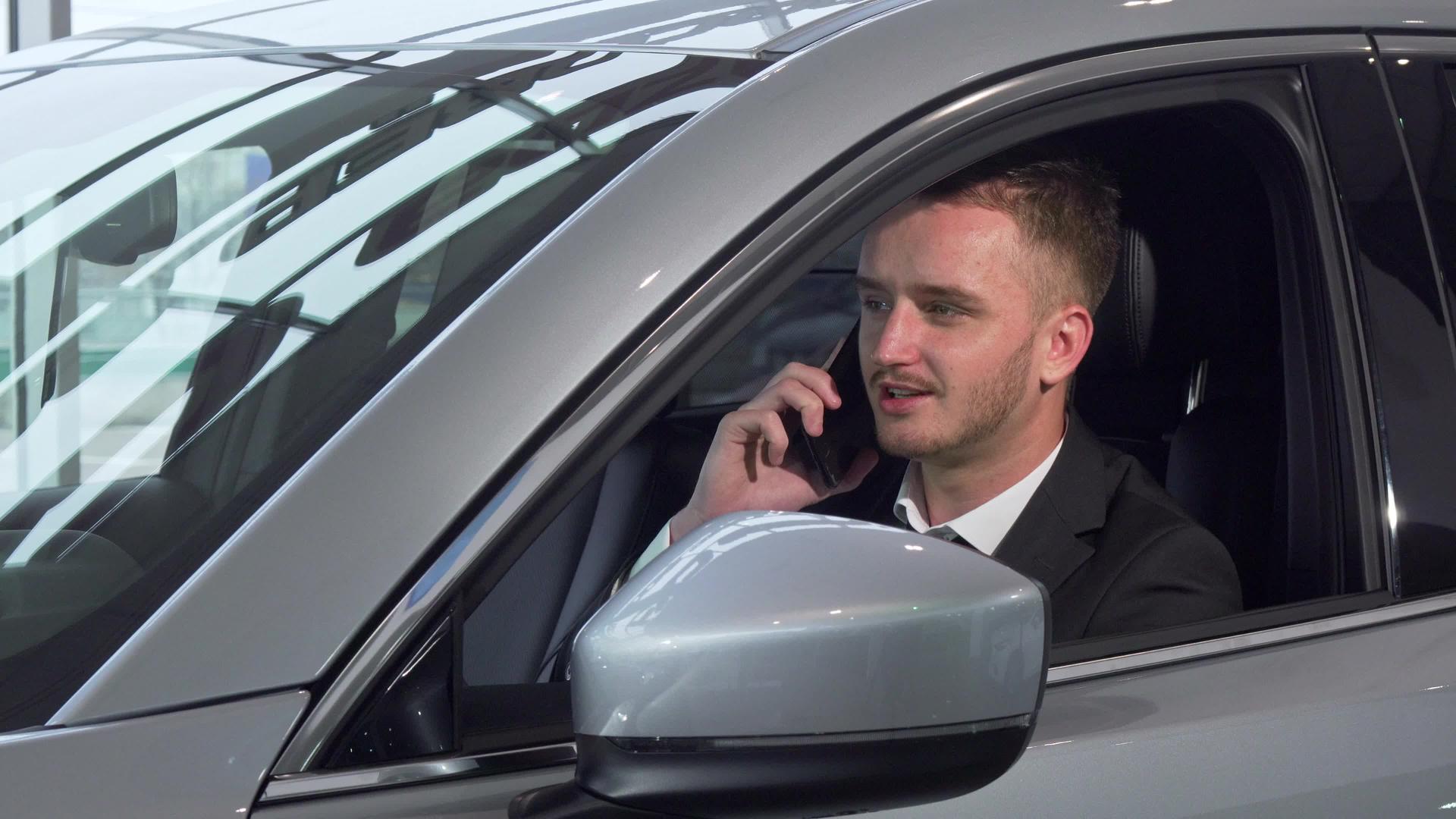 商人在电话里聊天坐在一辆新车上视频的预览图