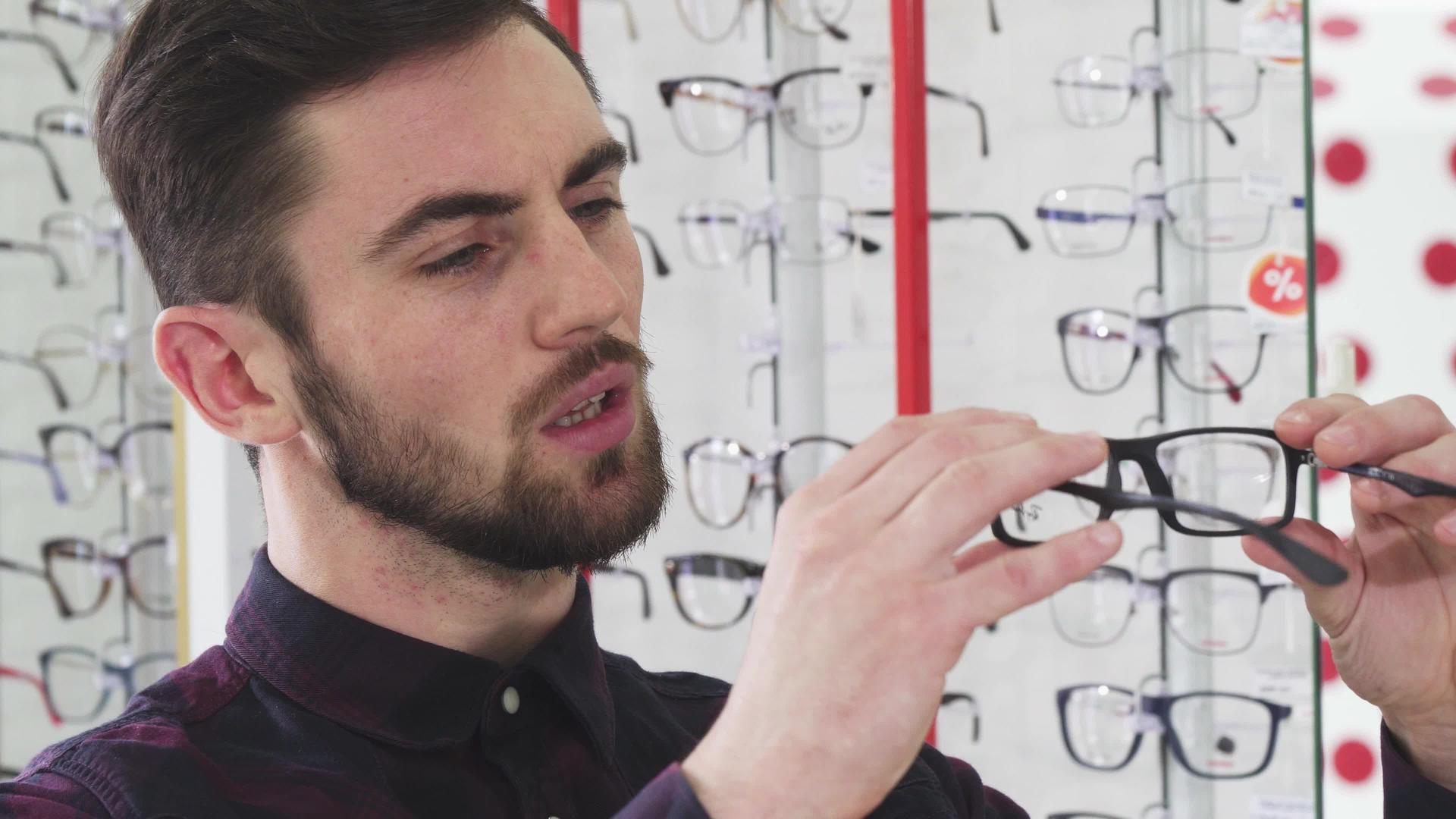 英俊的男人在验光师店检查了一副眼镜视频的预览图