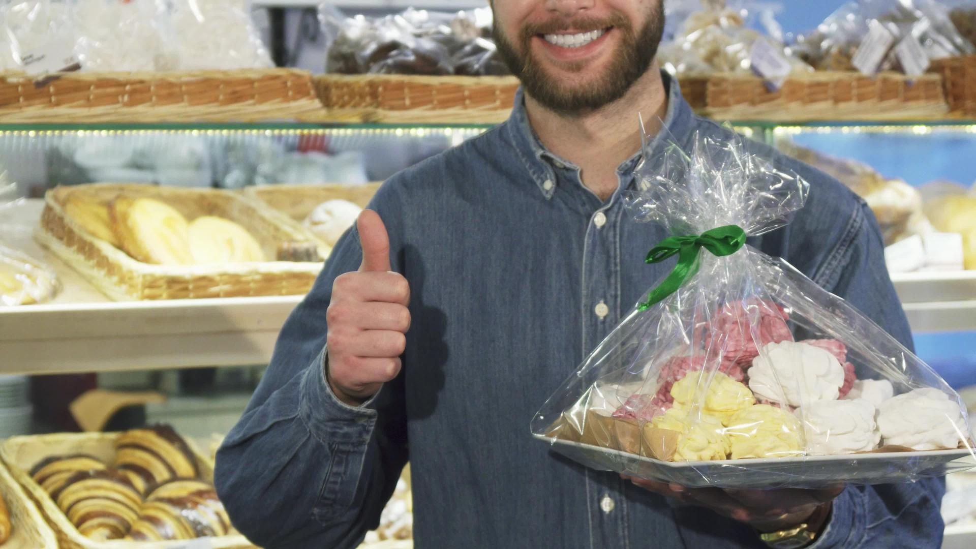 一个留着胡子的快乐男子在面包店露出了拇指的照片视频的预览图